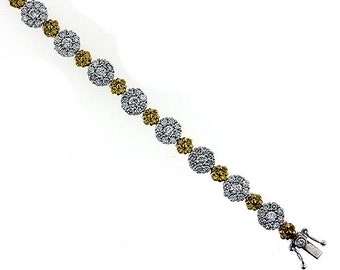 May include: A silver bracelet with alternating white and yellow diamond clusters.