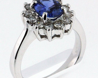 May include: A silver ring with a large oval blue sapphire surrounded by a halo of smaller diamonds.