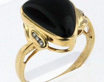 May include: A gold ring featuring a large, teardrop-shaped black stone. The ring has a gold band and is accented with small diamonds on the sides of the black stone. The ring is set against a white background.