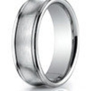 May include: A silver wedding band with a beveled edge and a slightly domed top.