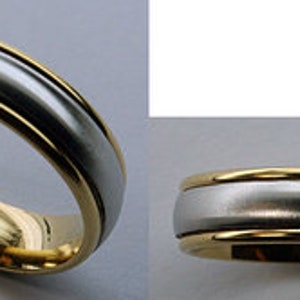 May include: A silver and gold wedding band with a smooth, polished finish.