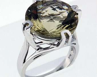 May include: A silver ring with a large, round, light green gemstone set in a delicate, intricate design.