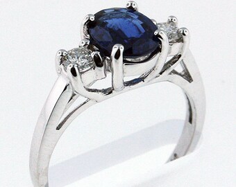 May include: A silver ring with a large oval blue sapphire and two smaller round diamonds.
