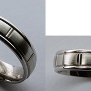 May include: A silver wedding band with a brushed finish and a subtle grooved design.