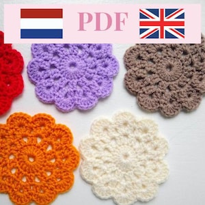 Op de afbeelding: Een verzameling handgemaakte, bloemvormige gehaakte onderzetters in verschillende kleuren: rood, oranje, paars, bruin en crème. De onderzetters hebben een open ontwerp. De afbeelding bevat ook de tekst "PDF" en de vlaggen van Nederland en het Verenigd Koninkrijk.