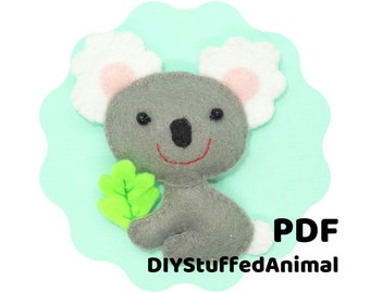 May include: A gray felt koala holding a green felt leaf. The koala has white felt ears with pink felt insides. The background is a light blue color. The text "PDF" and "DIYStuffedAnimal" is at the bottom of the image.