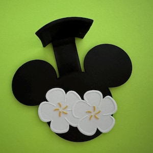 May include: Black and white Mickey Mouse head shaped wall hook with two white flowers attached to the bottom.