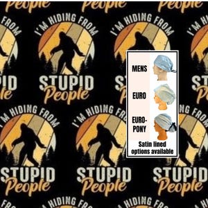 May include: Fabric featuring a repeating pattern of a black Bigfoot silhouette against a retro-style orange and yellow sunset circle with pine trees. Text reads I'M HIDING FROM STUPID PEOPLE. An inset shows three light blue scrub cap styles.