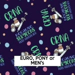 May include: A dark blue fabric featuring a repeating pattern of medical syringes, small vials, and the text CRNA BECAUSE SURGEONS NEED HEROES TOO in light green and blue, accented by scattered light blue, pink, and peach-colored polka dots.