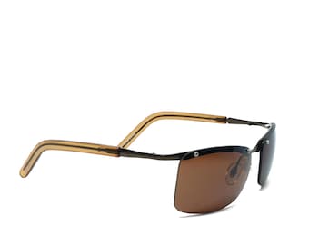 May include: A pair of brown sunglasses with a metal frame and brown lenses. The sunglasses have a flexible, spring-loaded arm.