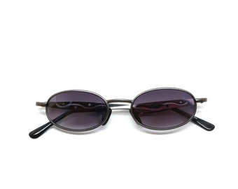 May include: A pair of oval-shaped sunglasses with a dark gray frame and lenses. The frame has a subtle wave design on the arms.