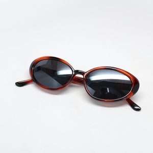 K&ouml;nnte beinhalten: Ovale Sonnenbrille in Schildpatt-Optik mit dunklen Gl&auml;sern.