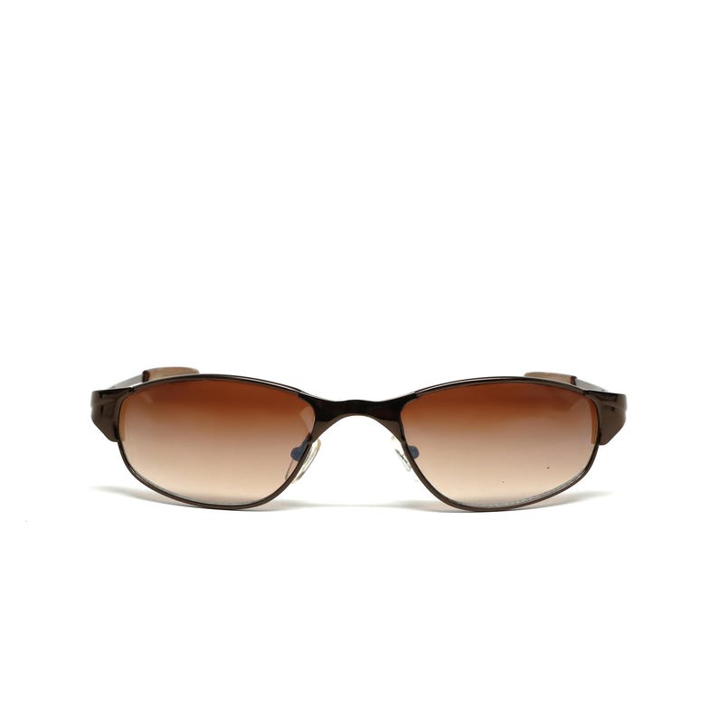 K&ouml;nnte beinhalten: Braune Sonnenbrille mit Metallrahmen und braunen get&ouml;nten Gl&auml;sern.