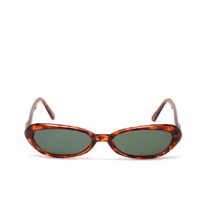 May include: Tortoise shell oval sunglasses with dark green lenses.