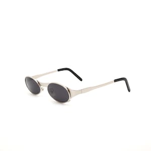 Puede incluir: Gafas de sol ovaladas plateadas con lentes negros y puntas de patillas negras.