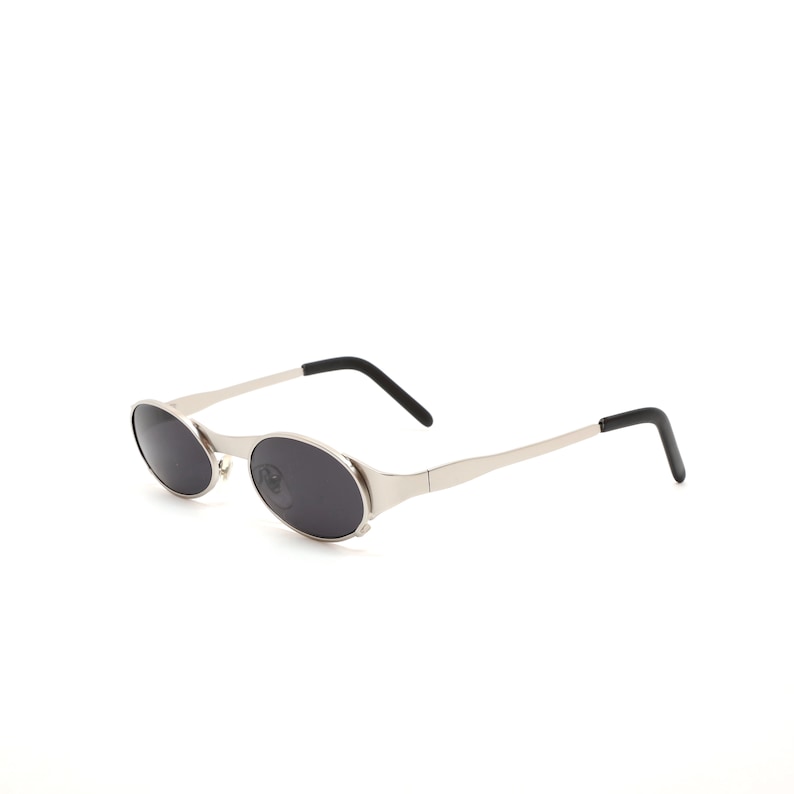 Puede incluir: Gafas de sol ovaladas plateadas con lentes negros y puntas de patillas negras.