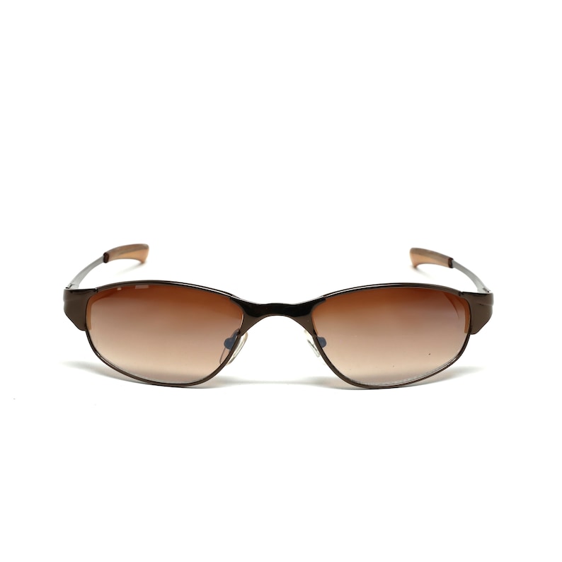 K&ouml;nnte beinhalten: Braune Sonnenbrille mit Metallrahmen und braunen Verlaufsgl&auml;sern.