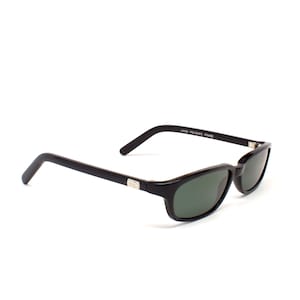 May include: Black sunglasses with a dark green lens and a black frame. The frame is labeled "HAND POLISHED FRAME".