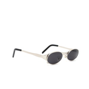 Puede incluir: Gafas de sol ovaladas plateadas con lentes negros y patillas negras.