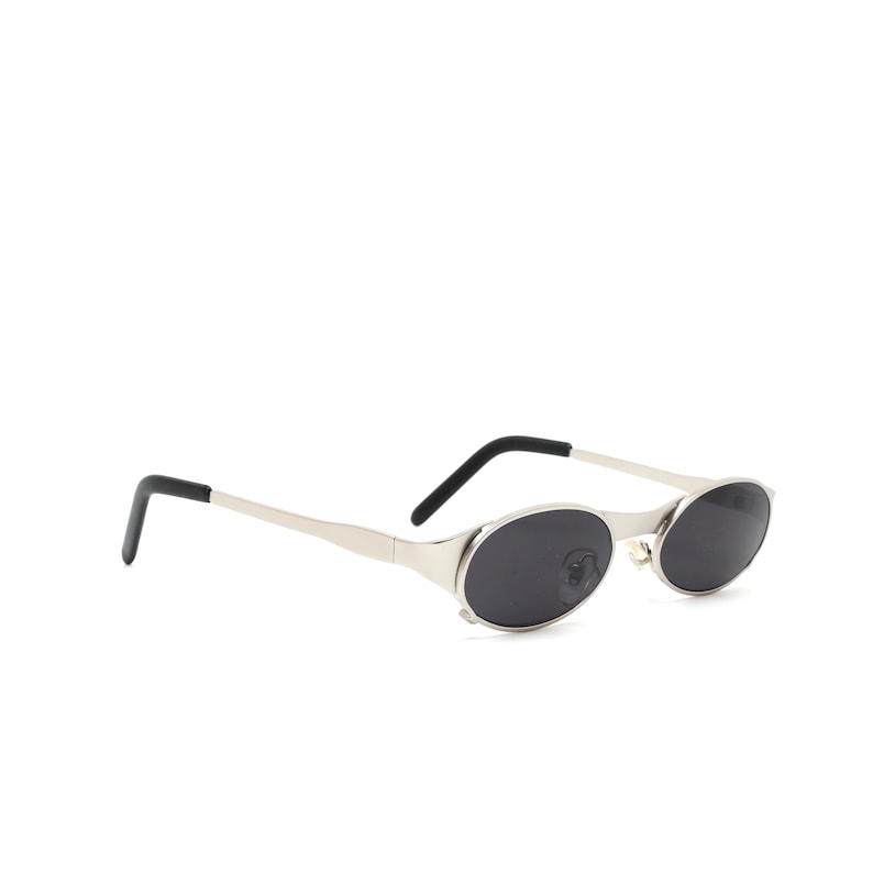 Puede incluir: Gafas de sol ovaladas plateadas con lentes negros y patillas negras.