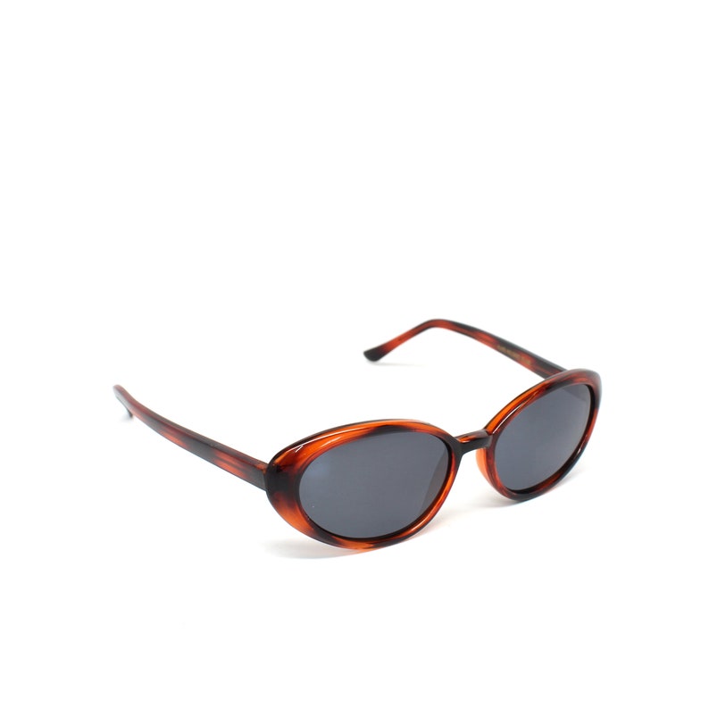 K&ouml;nnte beinhalten: Ovale Sonnenbrille in Schildpatt-Optik mit dunkelgrauen Gl&auml;sern.