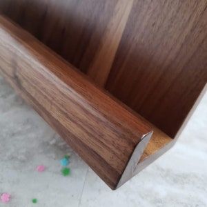 Puede incluir: Una estanter&iacute;a de pared de madera con un solo estante, hecha de madera marr&oacute;n oscura con un acabado de veta de madera natural.