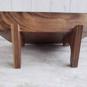 Puede incluir: Una bandeja de servir de madera con un acabado de madera natural y cuatro patas. La bandeja est&aacute; hecha de madera maciza y tiene una forma rectangular.
