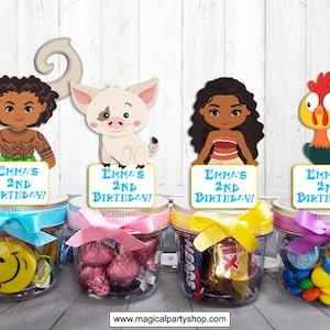 May include: Four clear glass jars with colorful ribbons and candy inside. Each jar has a personalized topper with a character from the animated movie Moana. The toppers say "Emma's 2nd Birthday!"