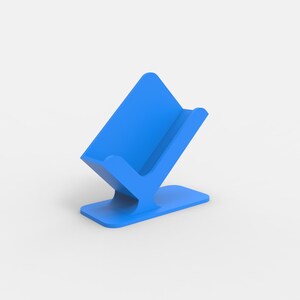 Op de afbeelding: Een blauwe telefoonstandaard van plastic met een gebogen basis en een verhoogde achterkant om een telefoon rechtop te houden.