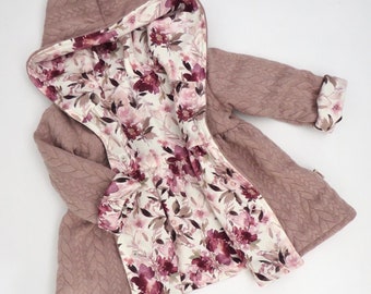 May include: A mauve quilted hooded jacket with a floral print lining. The jacket has a cable knit pattern and a cinched waist.