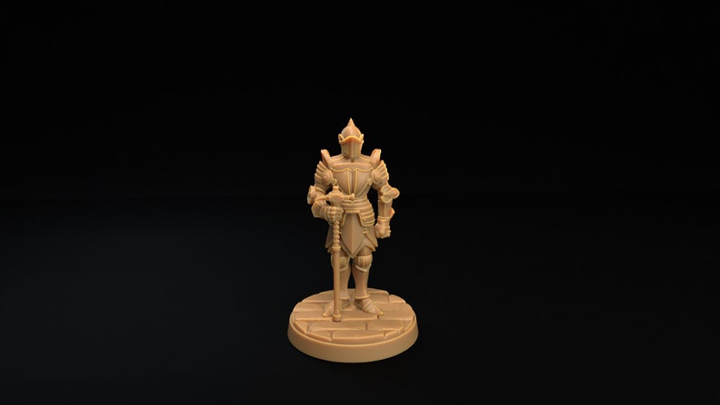 Op de afbeelding: Een miniatuur plastic figuur van een ridder in volledige bepantsering, die een zwaard vasthoudt. De ridder staat op een ronde basis met een steenachtige textuur.