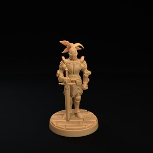 Op de afbeelding: Een miniatuurfiguur van een ridder in volledige bepantsering, die een zwaard vasthoudt. De ridder heeft een gevederde helm met hoorns en staat op een ronde basis.