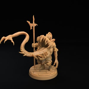 Op de afbeelding: Een bruin miniatuurbeeldje van een wezen met een grote mond en een lange, dunne staart. Het wezen houdt een speer in zijn rechterhand en heeft een dreigende uitdrukking op zijn gezicht.