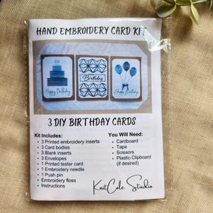 May include: A DIY hand embroidery card kit, packaged in plastic. The kit contains printed inserts, card bodies, blank inserts, envelopes, a tester card, needle, push pin, floss, and instructions. The cards have blue "Happy Birthday" designs.
