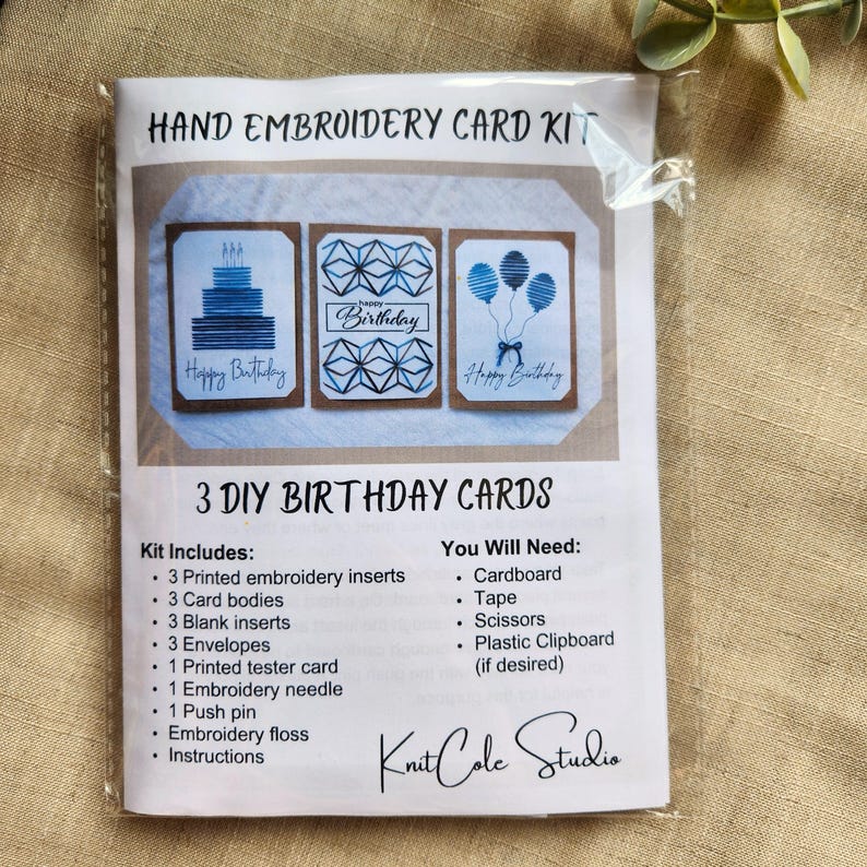 May include: A DIY hand embroidery card kit, packaged in plastic. The kit contains printed inserts, card bodies, blank inserts, envelopes, a tester card, needle, push pin, floss, and instructions. The cards have blue "Happy Birthday" designs.