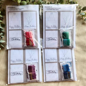 May include: Four clear plastic packages containing birthday card inserts and embroidery floss. Each package includes printed inserts with balloon and candle designs, and the words "Happy Birthday". The floss colours vary.
