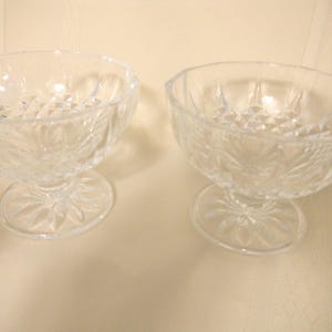 May include: Two clear glass dessert bowls with a diamond pattern and a pedestal base.