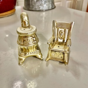 May include: Gold-tone metal salt and pepper shakers shaped like a wood-burning stove and a rocking chair.