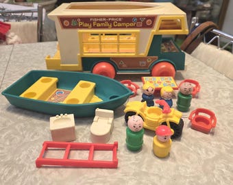 Puede incluir: Un juego de juguetes vintage Fisher-Price Play Family Camper. El juego incluye una caravana amarilla y verde, un bote verde azulado, un quad amarillo y varias figuras pequeñas y accesorios. La caravana tiene ruedas naranjas y el texto "Play Family Camper".