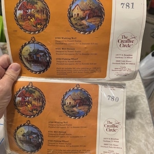 May include: Two packages of The Creative Circle kits, each with three circular landscape paintings. The kits include the text "Wishing Well", "Mill Stream", and "Fishing Wharf". Each design is approximately 8.8 cm in diameter.