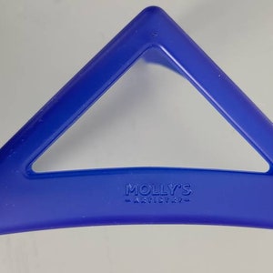 May include: A blue plastic triangle-shaped hair clip with the text "MOLLY'S -ARTISTRY- " embossed on the bottom.