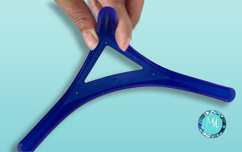May include: A blue plastic tool shaped like a triangle with three curved arms. The tool is designed to help with applying makeup.