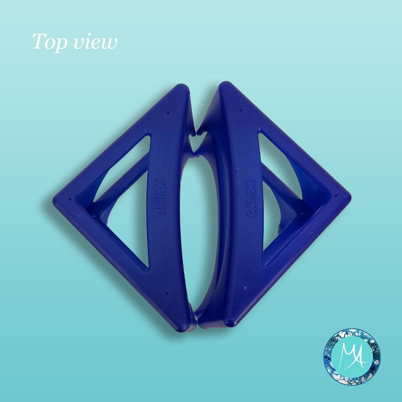 May include: A pair of blue plastic hair clips in the shape of a triangle. The clips are joined together at the top and have a curved shape in the middle.
