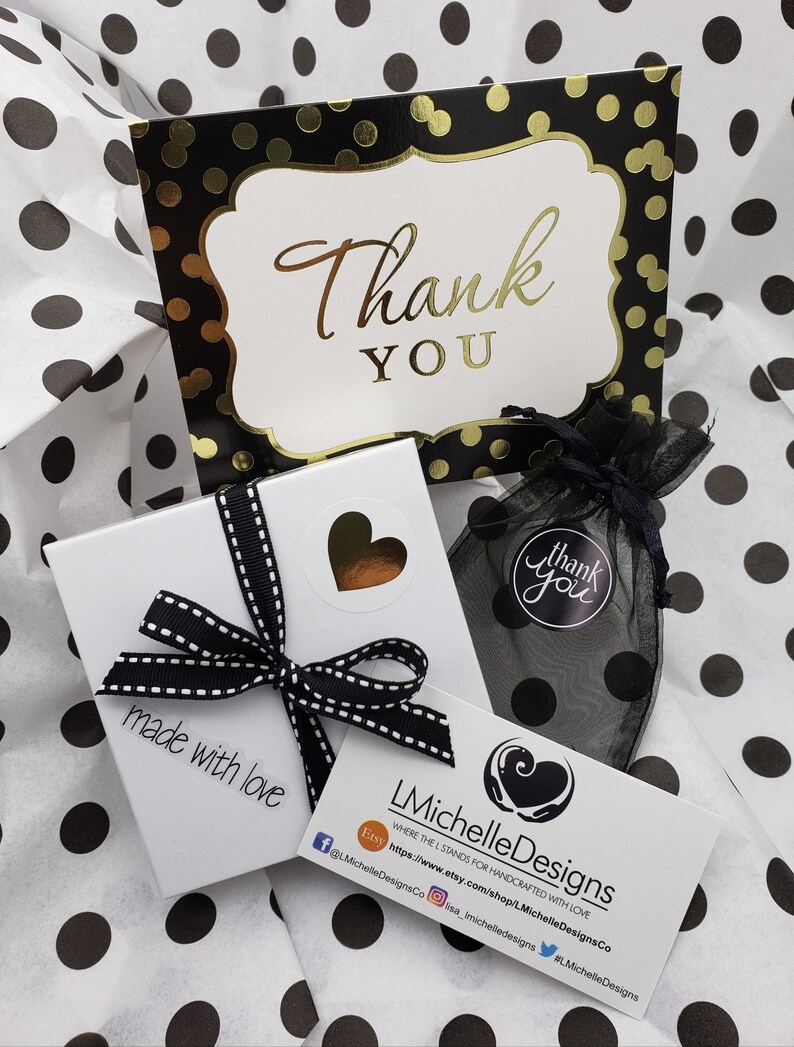 May include: A white gift box with a black and white ribbon, a black and white thank you card with gold polka dots, and a black and white thank you bag. The gift box has a sticker that says "made with love". The card has the text "Thank You". The bag has the text "Thank You".