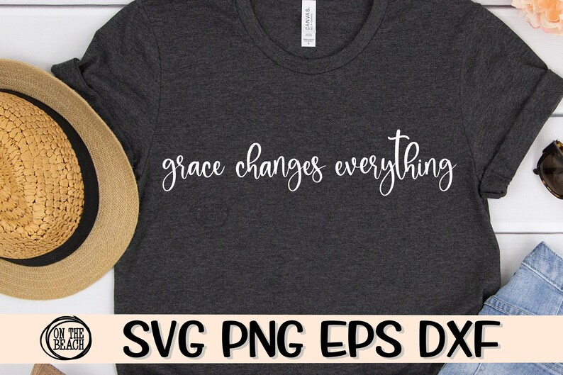 May include: A dark grey t-shirt with the text "grace changes everything" in white lettering. The shirt is lying flat on a white surface.