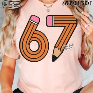 May include: A light pink t-shirt featuring the number 67 designed as pencils. The pencils are orange with black stripes, pink erasers, and brown tips. The shirt has the text "On The Beach Boutique" and "Original Creator of this design".