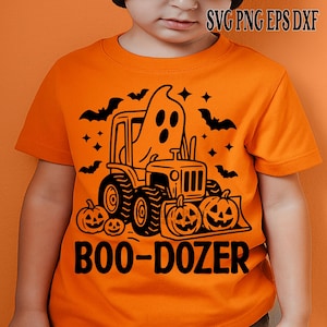 May include: Orange t-shirt with a black graphic of a tractor, ghost, pumpkins, bats, and stars. The text "BOO-DOZER" is below the tractor. A Halloween-themed design.