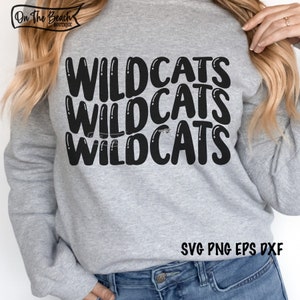 May include: Gray sweatshirt with the text "WILDCATS" repeated three times in a black, bold, bubble-like font. The text is centered on the sweatshirt. The bottom of the sweatshirt is visible, as well as the text "SVG PNG EPS DXF" in black.