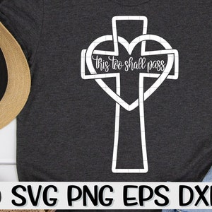 May include: A white outline of a cross with a heart intertwined. The text "This too shall pass" is written inside the heart.