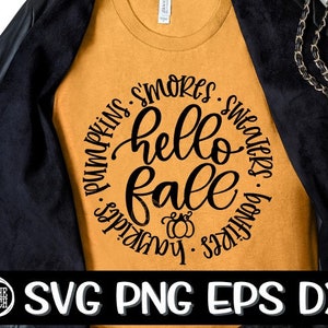 May include: A mustard yellow t-shirt with a black circle graphic that says "hello fall" surrounded by the words "pumpkins, s'mores, sweaters, bonfires, hayrides".
